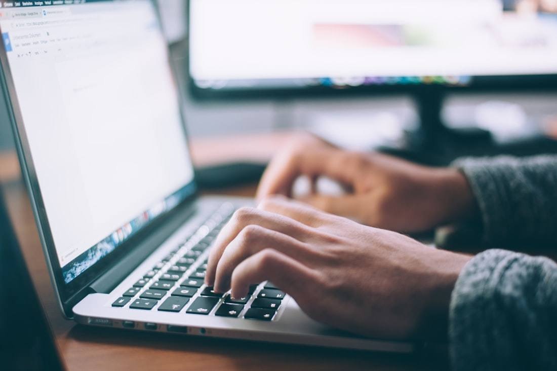 Hands on a laptop at a home workspace